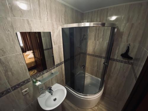 a bathroom with a shower and a sink and a mirror at Evropeyskiy in Kyiv