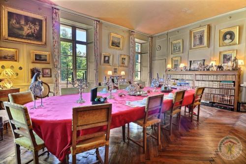 ein Esszimmer mit einem roten Tisch und Stühlen in der Unterkunft Château du Golf de la Freslonnière in Le Rheu