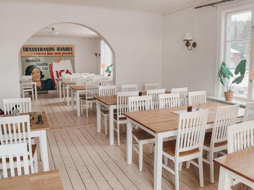 a dining room with wooden tables and white chairs at Vasacenter B&B in Transtrand