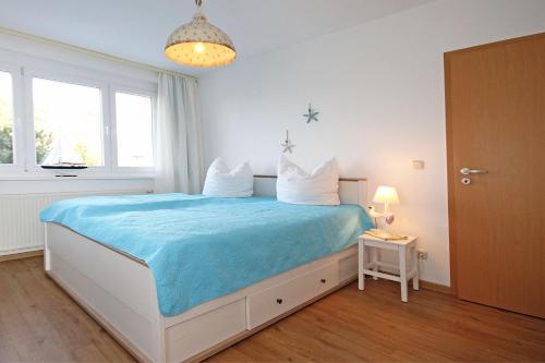 キュールングスボルンにあるDuenengarten-Schwalbennest-am-Meer-9662のベッドルーム1室(大型ベッド1台、青い毛布付)