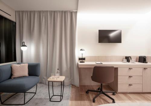 a living room with a chair and a desk and a chair at Swissôtel Kursaal Bern in Bern
