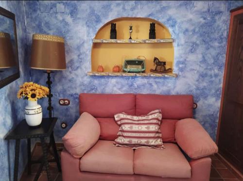 a pink couch in a room with blue walls at A la Sombra de la Torre in Serra
