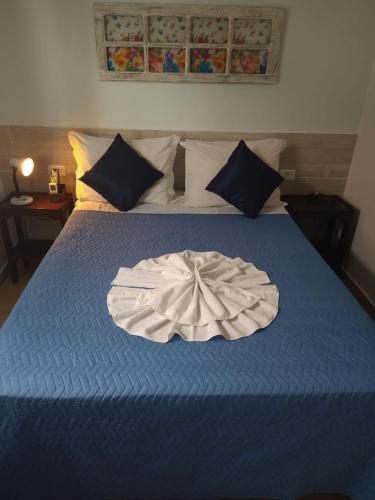 a blue bed with a white dress on it at Hotel Casarão Pitangueiras in Guarujá