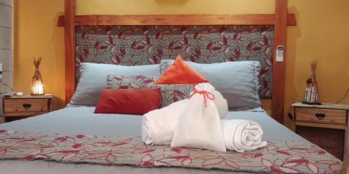 a bedroom with a bed with two bags on it at Nelumbo Petit Chalet in San Rafael