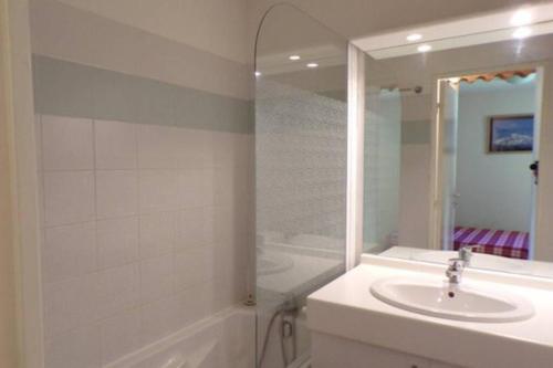 La salle de bains blanche est pourvue d'un lavabo et d'une douche. dans l'établissement Superbe appartement la Foux d'Allos, à La Foux