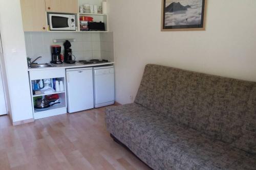 un salon avec un canapé et une cuisine dans l'établissement Superbe appartement la Foux d'Allos, à La Foux