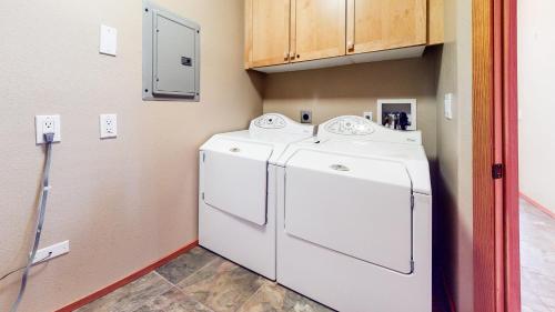a laundry room with a white refrigerator and cabinets at Snowcreek V #774 condo in Mammoth Lakes