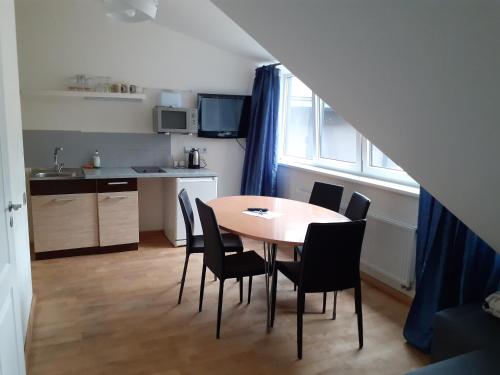 a kitchen and dining room with a table and chairs at Attic rooms at Laisves avenue in Kaunas