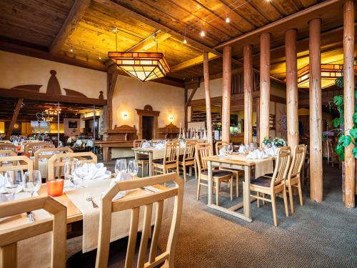 une salle à manger avec des tables et des chaises dans un restaurant dans l'établissement DANILO Savognin, à Savognin