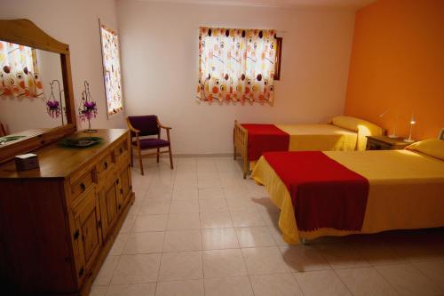 ein Hotelzimmer mit 2 Betten und einer Kommode in der Unterkunft Casa Anna, cerca la playa in Arona