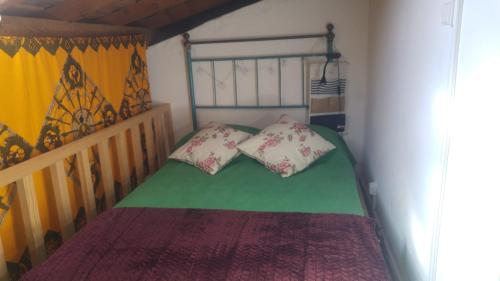 uma pequena cama com duas almofadas num quarto em Monchique Typical House em Monchique