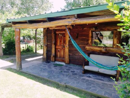 ein Blockhaus mit einer Hängematte draußen in der Unterkunft Cabañas Monje in Tandil