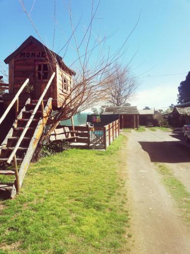 a building with a fence next to a dirt road at Cabañas Monje in Tandil