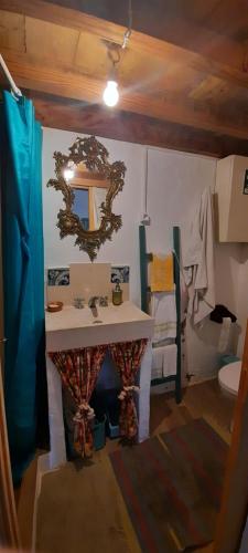 Monchique Typical House في مونشيك: حمام مع حوض ومرآة على الحائط