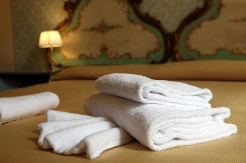 uma pilha de toalhas sentadas em cima de uma cama em Art Dreams B&B em Veneza