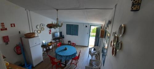 a room with a table and a kitchen with a refrigerator at Monchique Typical House in Monchique