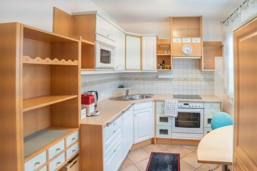 una cocina con armarios blancos y fregadero en Ferienwohnung Kristina en Bad Mitterndorf