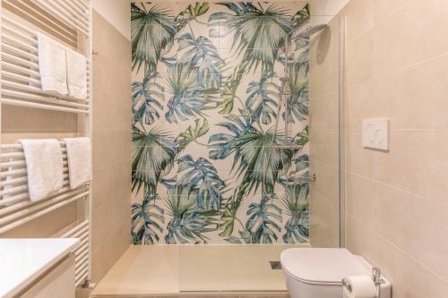 a bathroom with a toilet and a tropical wallpaper at Casa Balansina in Brenzone sul Garda