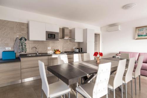 a kitchen with a dining table and white chairs at Casa Balansina in Brenzone sul Garda