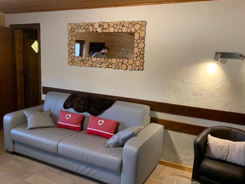 a person taking a picture of a couch in a room at APPARTEMENT PLEIN SUD AUX SAISIES n3 in Les Saisies
