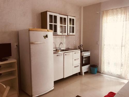 cocina con nevera, fregadero y fogones en Residencial Vila Sassari, en Florianópolis