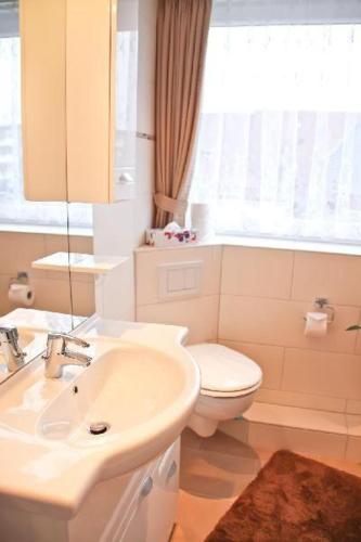 a bathroom with a sink and a toilet and a window at Nordsee-Residenz-City-App-18 in Westerland