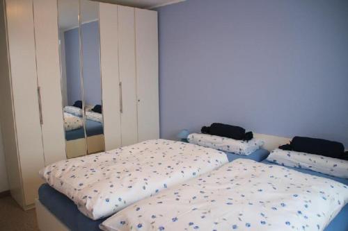 a bedroom with two beds and a mirror at Nordsee-Residenz-City-App-18 in Westerland