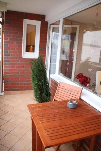 a wooden bench sitting on a porch with a table at Nordsee-Residenz-City-App-18 in Westerland