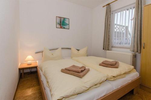 ein Schlafzimmer mit einem Bett mit zwei Handtüchern darauf in der Unterkunft Ferienwohnung für 2 Erwachsene auf Rügen in Groß Banzelvitz