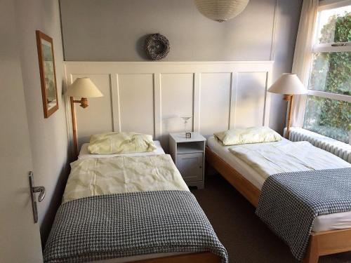 ein kleines Schlafzimmer mit 2 Betten und einem Fenster in der Unterkunft Haus Mühlenpark in Wyk auf Föhr