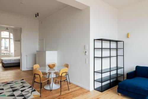 een keuken en een woonkamer met een tafel en stoelen bij Savoie in Brussel