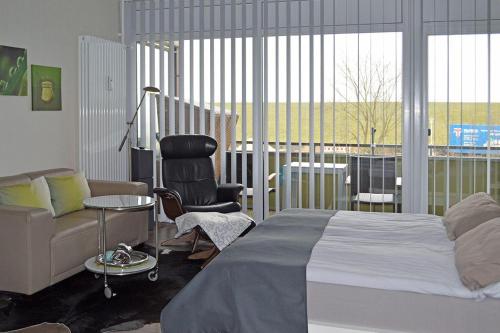a bedroom with a bed and a chair and a couch at Encore-ONE in Büsum
