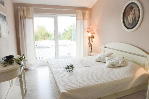 - une chambre avec un lit blanc et un balcon dans l'établissement Domizil Opatija A&N, Villa mit Pool, Wohlfühloase mit Meerblick, à Poljane