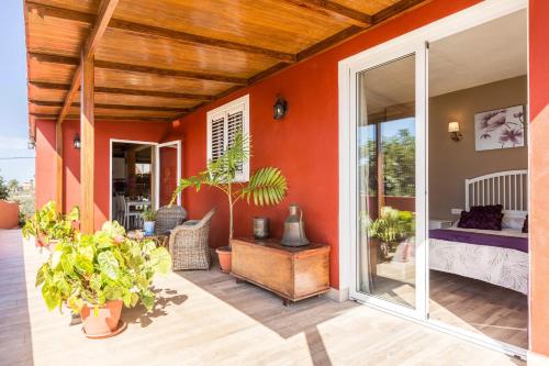 eine Veranda mit Pflanzen und ein Zimmer mit einem Bett in der Unterkunft Casa Quintana - Apartamento Carla in Tijarafe