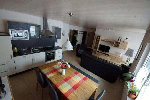 a kitchen and a living room with a table in a room at Ferienwohnung-am-Foerstereck in Freudenstadt