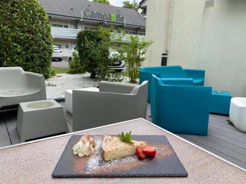 une assiette de nourriture sur une table sur un patio dans l'établissement Campanile Tours Sud ~ Joué-Les-Tours, à Joué-lès-Tours