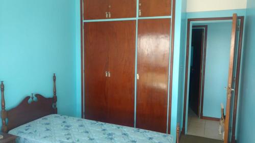 1 dormitorio con 1 cama y armario de madera en Departamento con Vista al Mar en Mar del Plata