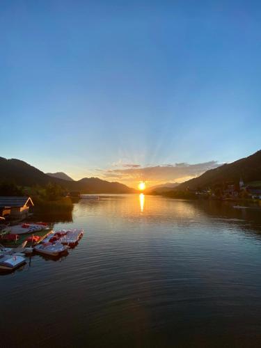a group of boats on a lake at sunset at Pension Seeheim in Weissensee
