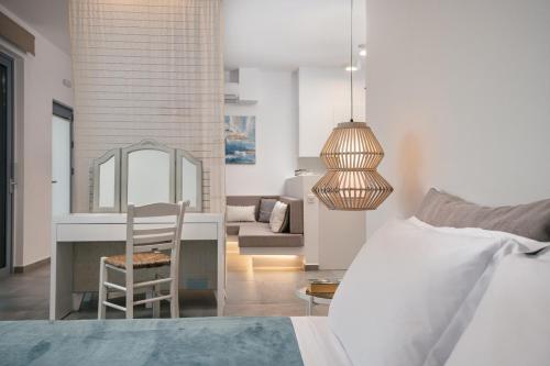 a bedroom with a bed and a chair and a living room at Zante Fiore Suites in Xirokástellon