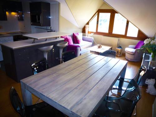 a kitchen and living room with a wooden table at Apartamentos Formigal - admite mascotas in Formigal