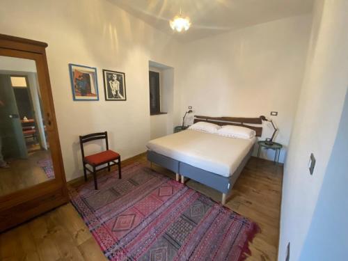 1 dormitorio con 1 cama, 1 silla y 1 alfombra en B&B Donna Livia, en Cantalupo nel Sannio