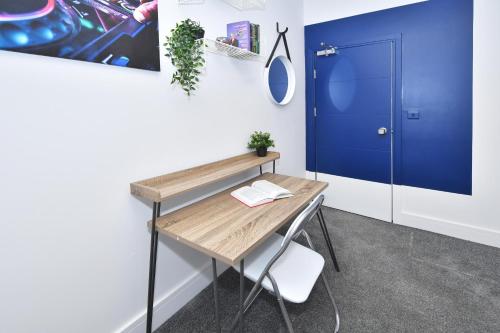 einen Schreibtisch in einem Zimmer mit blauer Tür in der Unterkunft Townhouse @ 42 Minshull New Road Crewe in Crewe