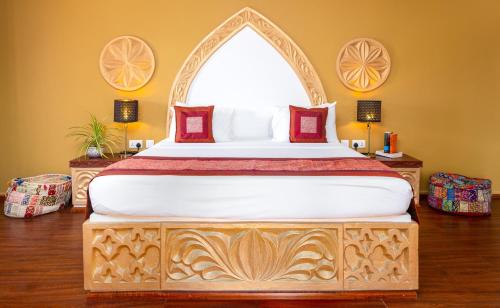 a bedroom with a large bed with a wooden frame at Kibanda Natural Kendwa Villa in Kendwa