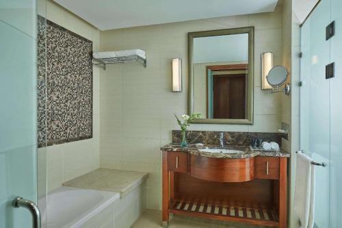 a bathroom with a sink and a tub and a mirror at Steigenberger Pyramids Cairo in Cairo