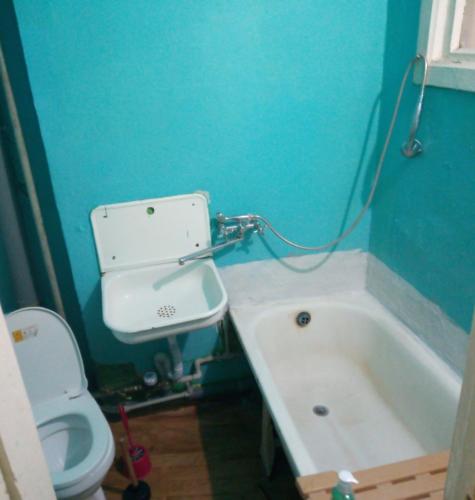 a bathroom with a toilet and a bath tub at однокомнатная квартира in Nova Kakhovka