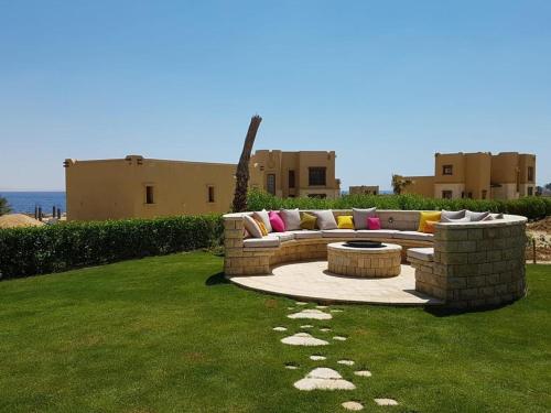 Byoum Vacation House في الفيوم: كنب جالس على العشب في ساحة