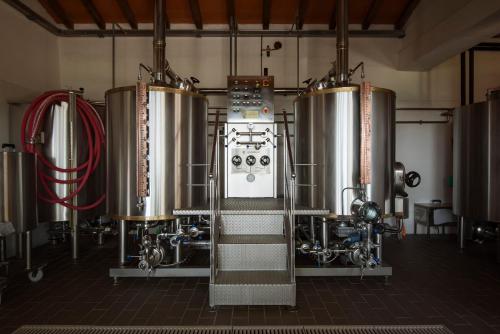 una fila di cisterne di vino in una fabbrica di birra di Podere I Massoni a Monterotondo