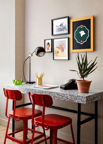 a desk with two red chairs and a table with a computer at Graduate by Hilton Tucson in Tucson