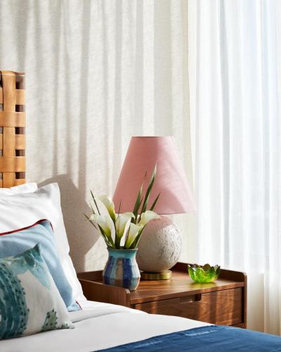 a table with a lamp and a vase with a plant at Graduate by Hilton Tucson in Tucson