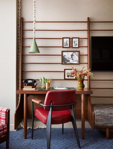 a room with a desk with a red chair and a television at Graduate by Hilton Tucson in Tucson